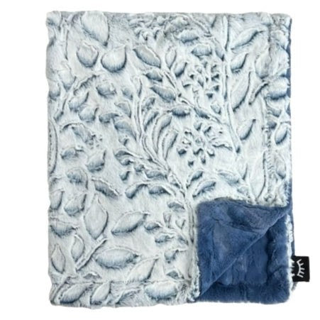 Textured blanket with leaf pattern and blue reverse side on a white background